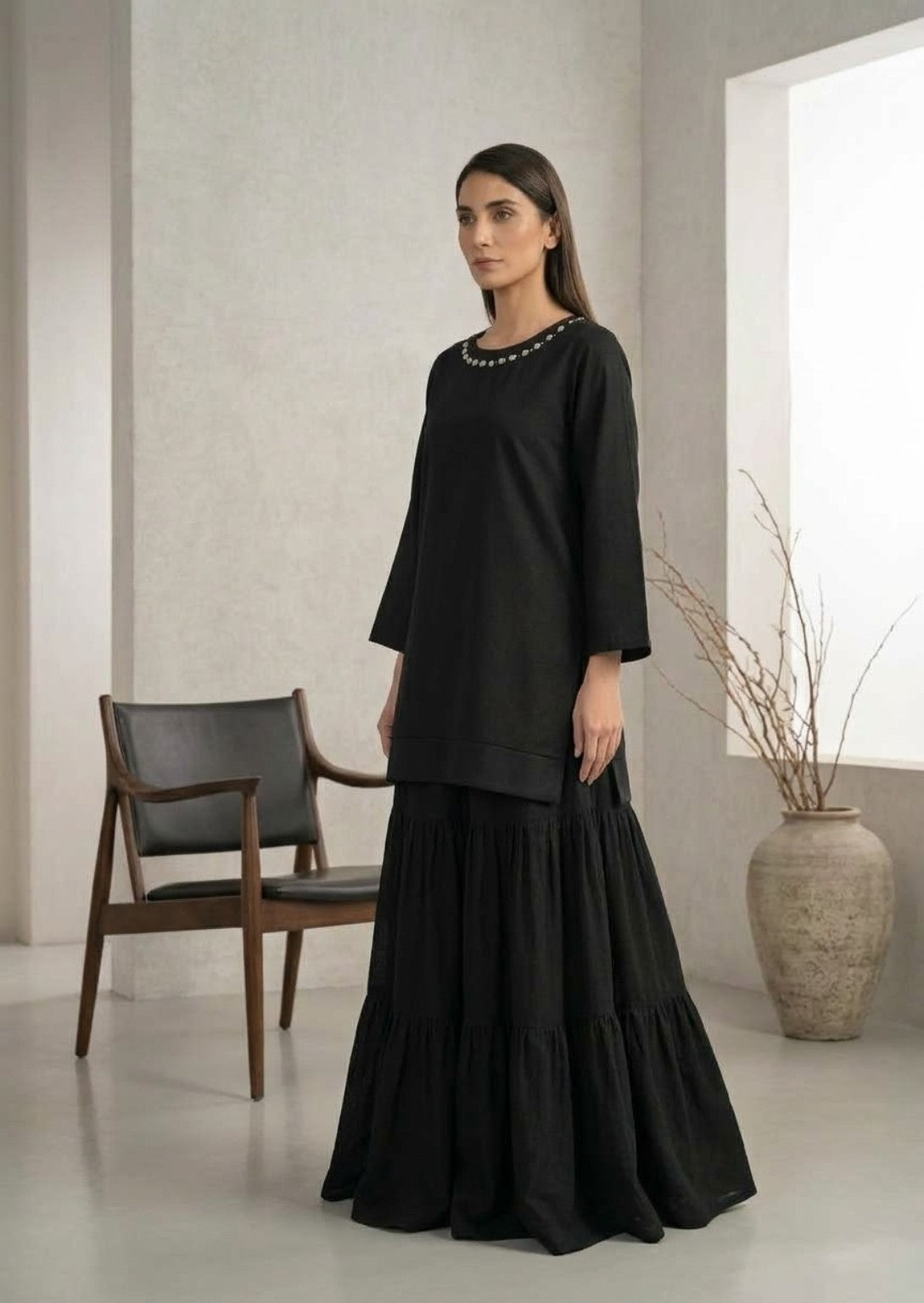 Three-quarter view of black kurta and matching tiered skirt