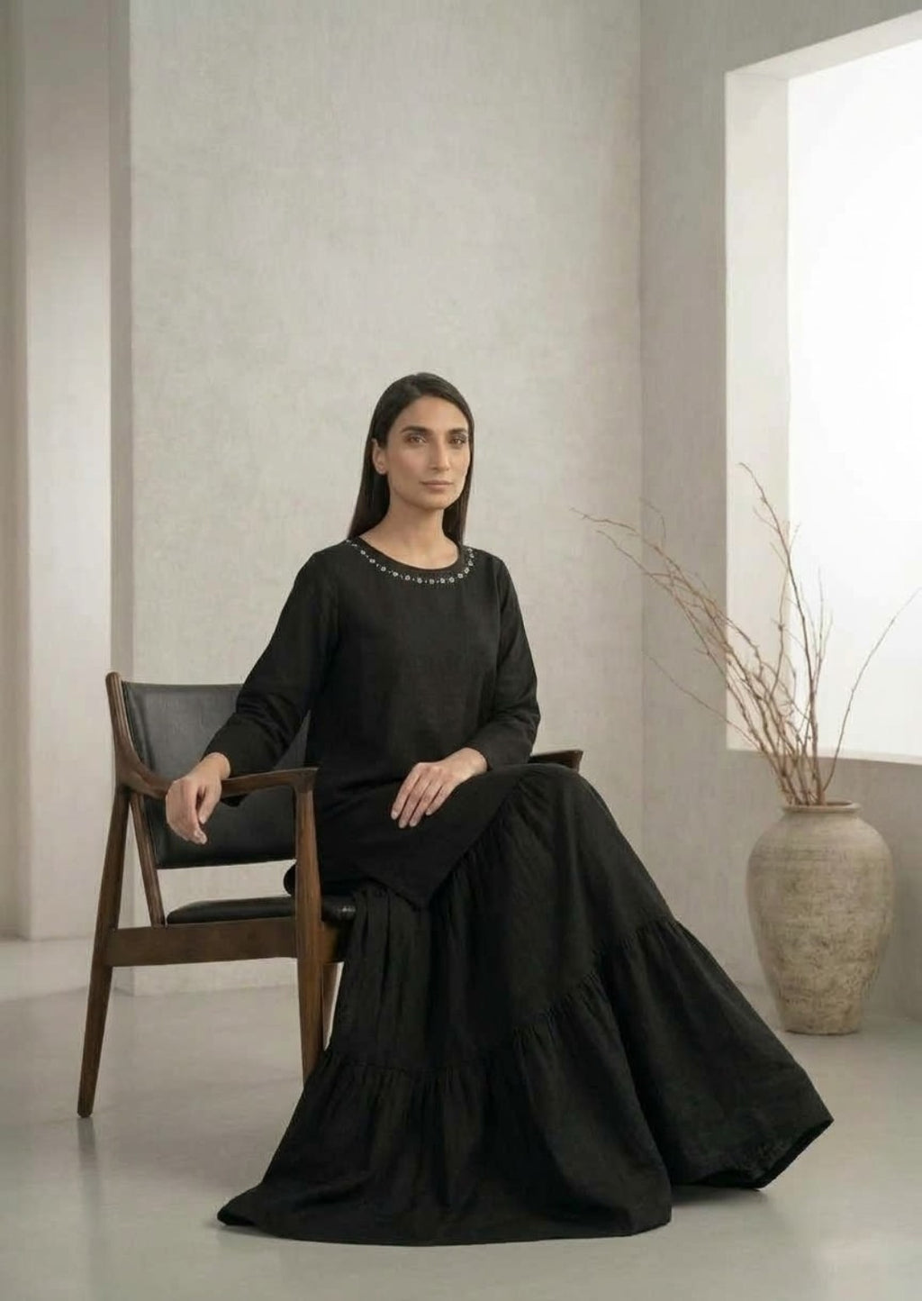 Black kurta and tiered skirt outfit seated styling view