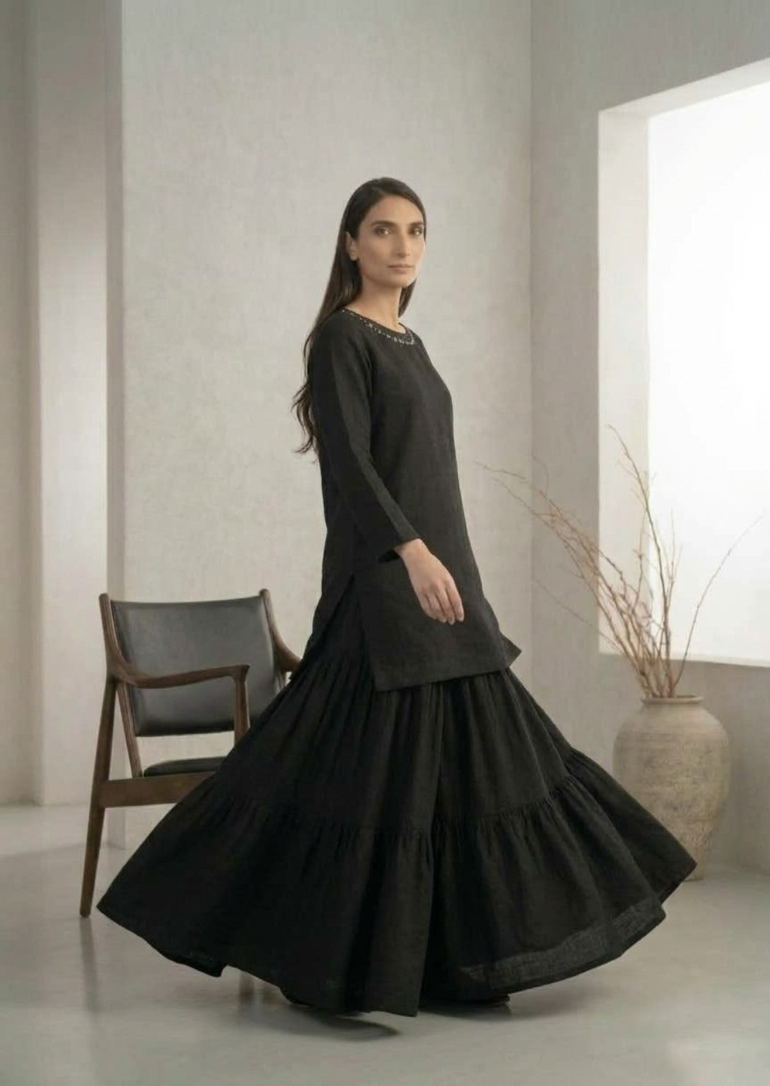 Side view of black kurta and flowing tiered skirt